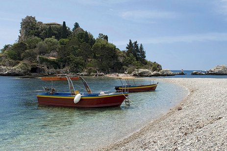 Sonniger Strand in Italien mit türkisfarbenem Wasser.