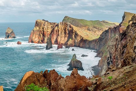 Küstenlandschaft auf Madeira mit Felsen, klarem Wasser und einer Promenade.