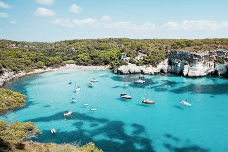 Strand in Spanien mit goldgelbem Sand, klarem Wasser und entspannter Atmosphäre.